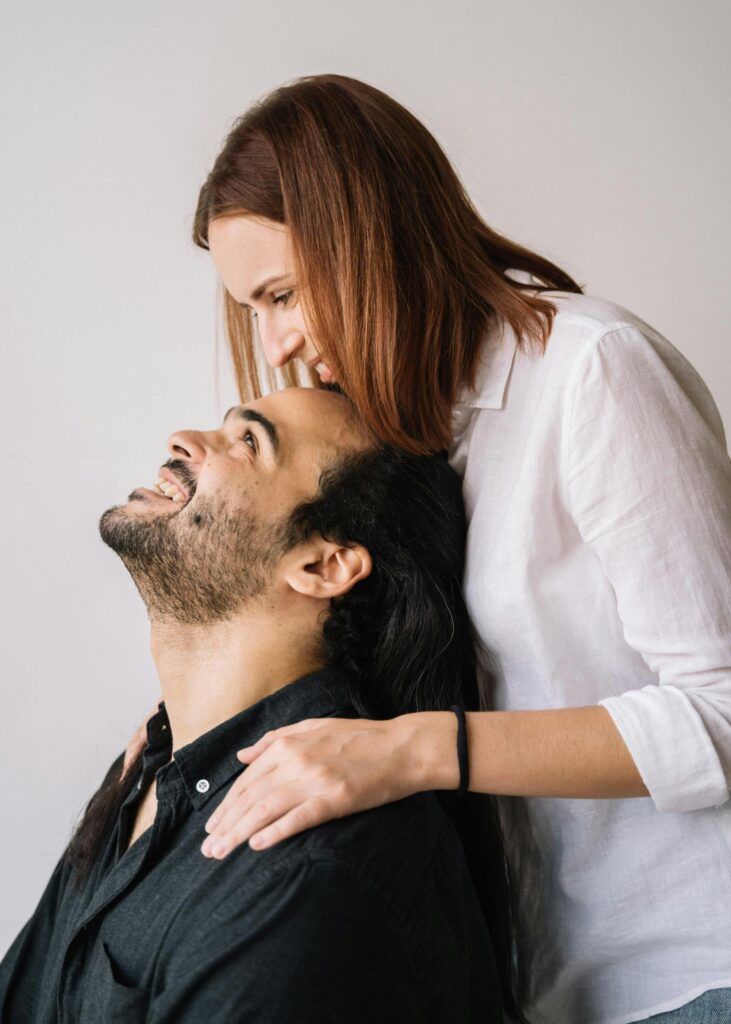 A happy couple embracing and expressing love inside a cozy setting.